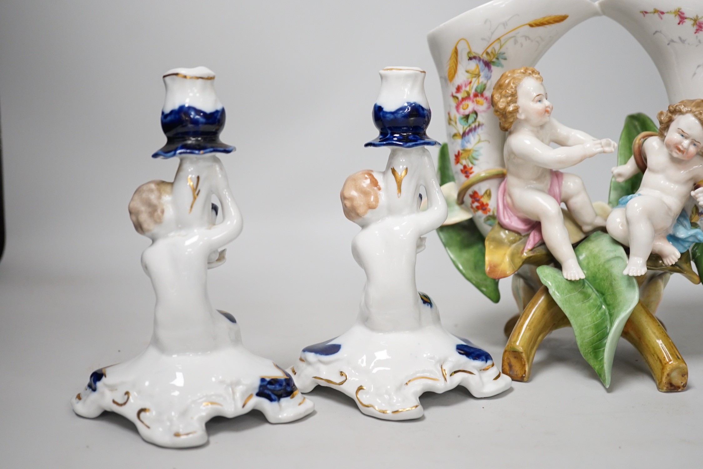 A pair of candlesticks and a figure group flower vase. Tallest 20cm